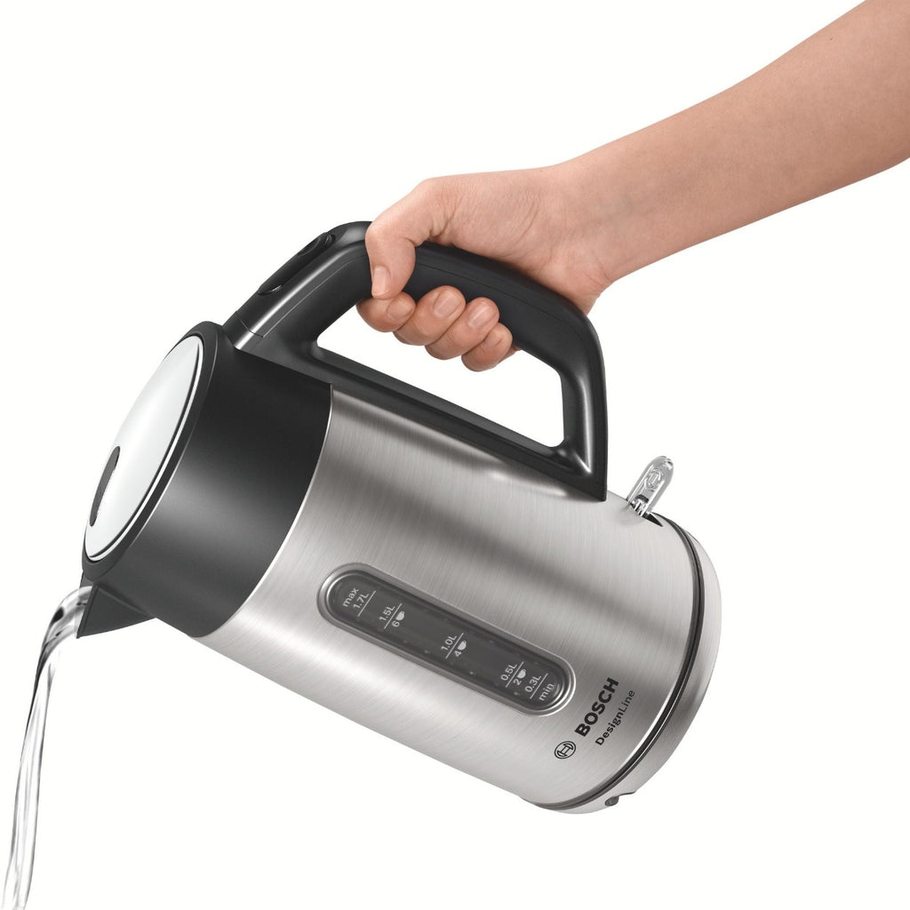 arm pouring water from a stainless steel electric kettle